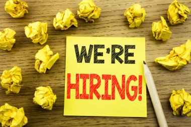 Word, biz çoğu işe şimdi yazma. İş kavramı için işe alım insan kaynakları ahşap arka plan üzerinde yapışkan not kağıt üzerinde yazılı. Sarı kağıtları arka plan üzerinde katlanmış