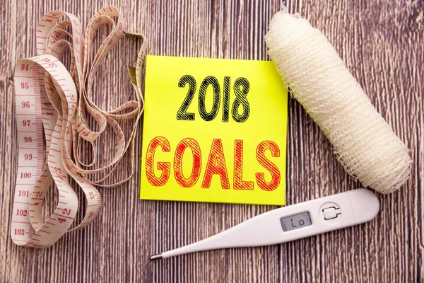 2018 Goals. Business fitness health concept for financial planning, business strategy written sticky note empty paper background with copy space bandage and thermometer