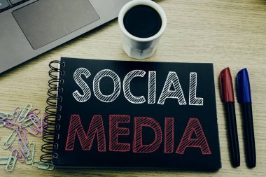 Sosyal medya gösteren el yazısı duyuru metin. İş kavramı topluluk sosyal defter kitap dizüstü kahve ile ofiste ahşap arka plan üzerinde yazılı medya için