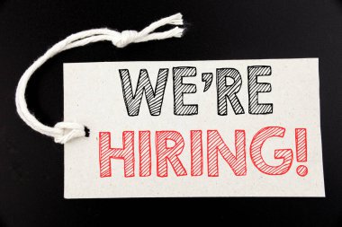 El yazısı metnini başlık biz çoğu işe şimdi gösteriyor. İş kavramı için işe alım insan kaynakları siyah vintage arka plan üzerinde fiyat etiketi kağıda yazılı yazma.