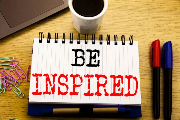 Подпись к тексту от руки, показывающая Be Inspired. Бизнес-концепция для Inspirit и Мбаппе написана в тетрадке на деревянном фоне в офисе с кофе для ноутбука — стоковое фото