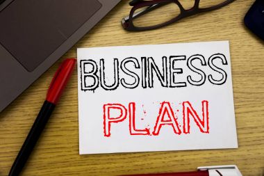 İş planı planlama gösteren el yazısı duyuru metin. İş kavramı için hazırlık proje stratejisi içinde yazıhane kopya alanı, pen marker ve gözlük ile kağıt, ahşap zemin üzerine yazılmış