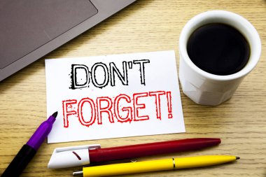 El yazısı metnini başlık gösterilen unutmayın. Uyarı mektubu defter kitap dizüstü kahve ile ofiste ahşap arka plan üzerinde Yazılı mesaj yazma iş kavramı