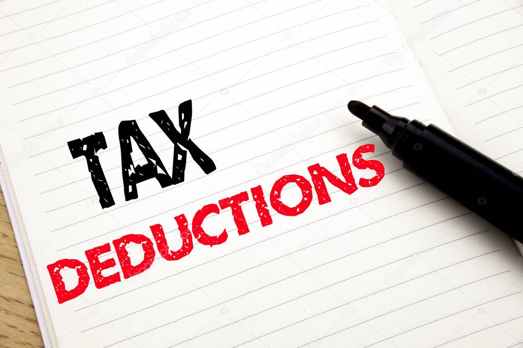 Tax Deductions. Business concept for Finance Incoming Tax Money Deduction written on notebook with copy space on book background with marker pen