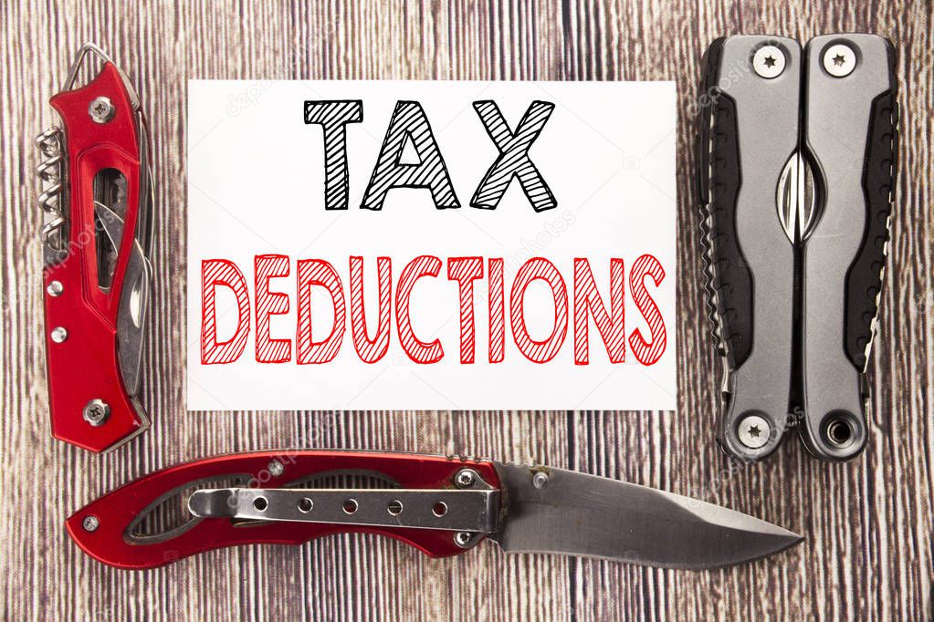 Conceptual hand writing text caption inspiration showing Tax Deductions. Business concept for Finance Incoming Tax Money Deduction Written on sticky note wooden background with pocket knife