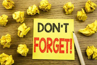 Word, unutmayın yazma. İş kavramı için anımsatıcı iletisi ahşap arka plan üzerinde yapışkan not kağıt üzerinde yazılı. Sarı kağıtları arka plan üzerinde katlanmış