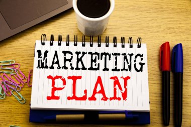 Pazarlama planı gösterilen metin resim yazısı yazma el. İş kavramı başarılı defter kitap dizüstü kahve ile ofiste ahşap arka plan üzerinde yazılı Strateji planlama için