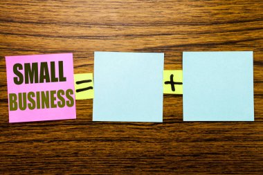 Küçük işletme gösterilen metin yazma. Aile sahibi ahşap arka plan üzerinde yapışkan not kağıt üzerinde yazılı şirket için iş kavramı. Denklem matematiksel alanınızı artı işareti ile