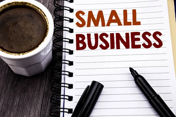 Escrever texto mostrando Small Business. Conceito de negócio para a Family Owned Company escrito em papel de nota de caderno sobre o fundo de madeira. Com café e marcador preto . — Fotografia de Stock