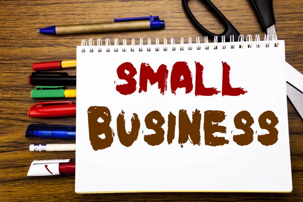 Palavra, escrevendo Small Business. Conceito de negócio para a empresa familiar Escrito em notebook, fundo de madeira com equipamento de escritório como canetas tesoura marcador colorido — Fotografia de Stock