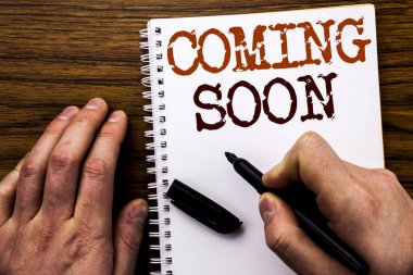 El yazısı metnini gösteren wordcoming yakında. Gelecek mesaj yazılmış tablet laptop, işadamı el, parmak defter kitap yazma ile ahşap arka plan için iş kavramı.