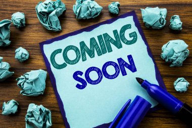 Coming Soon gösterilen metin yazma. Yapışkan Not kağıt üzerinde iş kavramı mesaj gelecek yazılı için marker ile ahşap arka plan sarı kağıt anlam düşünme katlanmış. 