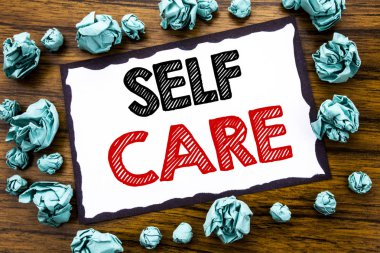 Kendine iyi bak gösterilen metin resim yazısı ilham yazma el. Kendi sağlık yazılı yapışkan not kağıdı, tatil güneş gözlüğü ve kalın marker ile ahşap arka plan için bakım ayırdığınız için iş kavramı