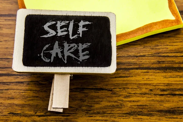 Texto manuscrito mostrando Self Care. Conceito de negócio para cuidar da própria saúde escrito no quadro de anúncios sobre o fundo de madeira . — Fotografia de Stock