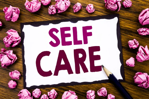 Hand writing text caption inspiration showing Self Care. Business concept for Taking caring for own Health Written on sticky note paper, wooden background with folded pink paper meaning thinking — Stock Photo, Image