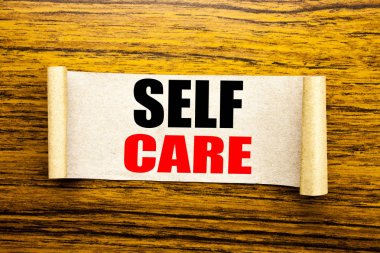 Kendine iyi bak gösterilen metin resim yazısı ilham yazma el. Yapışkan not kağıdına ahşap arka plan üzerinde yazılı kendi sağlık için bakım ayırdığınız için iş kavramı.