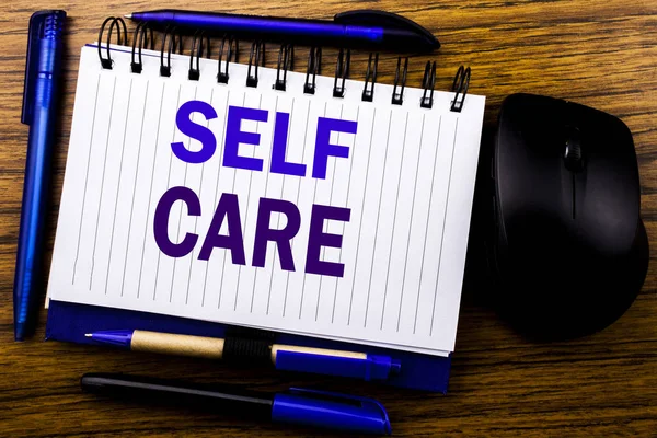 Kendine iyi bak gösteren el yazısı metin. Defter kitap bir not kağıdına ahşap arka plan üzerinde yazılı kendi sağlık için bakım ayırdığınız için iş kavramı. Mavi word mektup. Fare için ileri.