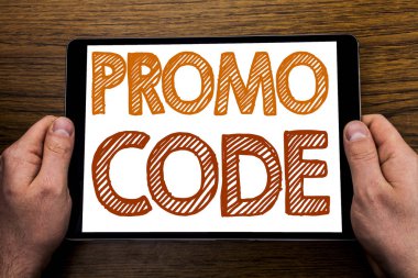 El metin resim yazısı promosyon kodu yazma. Online iş yazılı tablet laptop, işadamı el Pc tutan parmak ile ahşap arka plan için promosyon için iş kavramı.