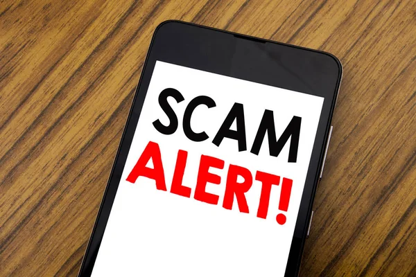 Mot, écriture manuscrite Scam Alert. Concept d'entreprise pour la fraude Avertissement Écrit sur téléphone portable, fond en bois avec espace de copie . — Photo