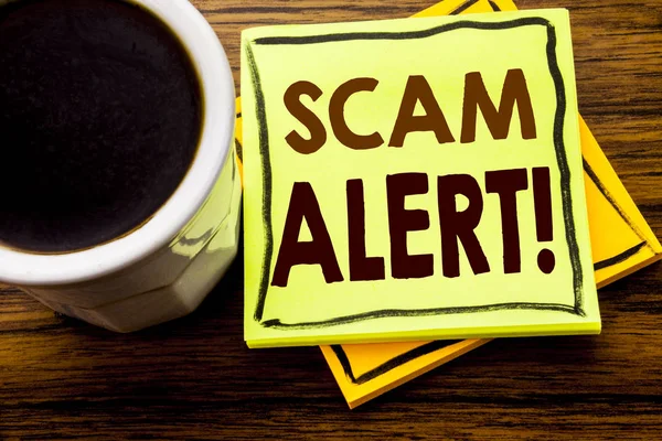 Handwritten text showing Scam Alert. Business concept for Fraud Warning written on sticky note paper on the wooden wood background with coffee cup — Stock Photo, Image