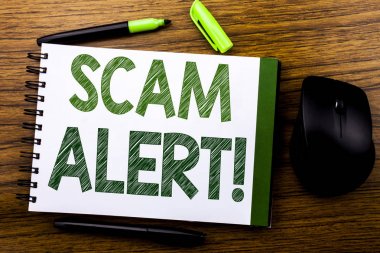 Scam Uyarısı gösteren el yazısı duyuru metin. İş kavramı dolandırıcılık defter kitap bir not kağıdına ahşap arka plan üzerinde yazılı uyarı için. Yeşil word mektup. Fare için ileri.