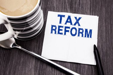 Vergi reformu gösteren el yazısı metin. Ahşap ahşap arka plan doku kağıt mendil yazılı vergi hükümet değişikliği için iş kavramı. Cilt kalemi ve kahve ile. Office Üstten Görünüm.