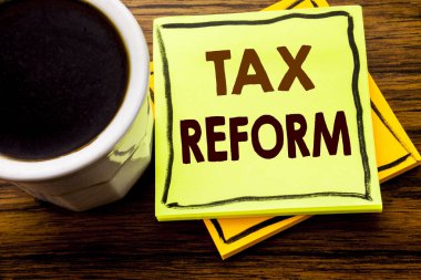 Vergi reformu gösteren el yazısı metin. Ahşap ahşap arka plan kahve fincanı ile yapışkan not kağıdına yazılı vergi hükümet değişikliği için iş kavramı