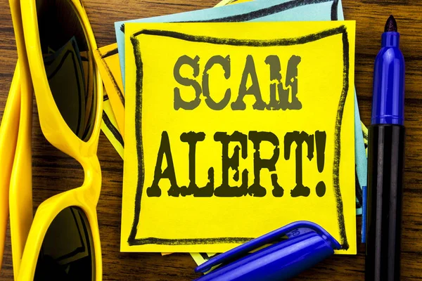 Scrittura a mano testo didascalia ispirazione mostrando Scam Alert. Business concept for Fraud Warning Scritto su carta da lettere adesiva, fondo in legno con occhiali da sole per le vacanze e pennarello audace — Foto Stock