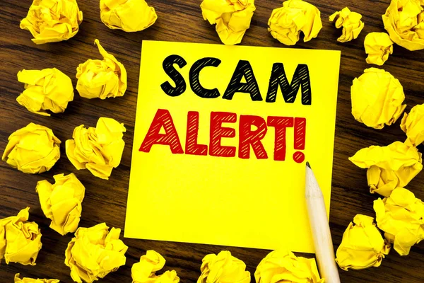 Writing text showing Scam Alert. Business concept for Fraud Warning Written on sticky note paper, wooden background with folded yellow paper meaning thinking