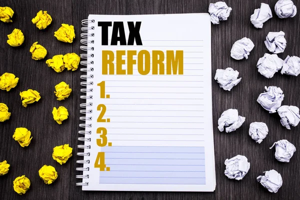 Концептуальная рукописная надпись, показывающая налоговую реформу. Бизнес-концепция изменения налога на прибыль, написанная на блокноте записной книжки, деревянный фон с липким сложенным желтым и белым фоном — стоковое фото
