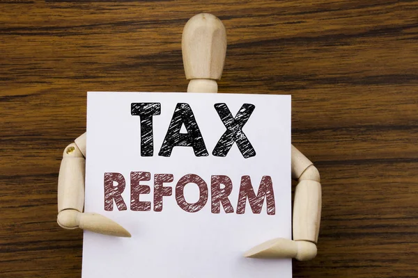 Conceptual hand writing text caption inspiration showing Tax Reform. Business concept for Government Change in Taxes written on sticky note paper on the wooden background. Holding by the sculpture. — Stock Photo, Image