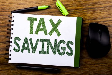 Tex tasarruf gösteren el yazısı duyuru metin. İş kavramı vergi tasarruf ekstra para defter kitap bir not kağıdına ahşap arka plan üzerinde yazılı iade için. Yeşil word mektup. Fare için ileri.