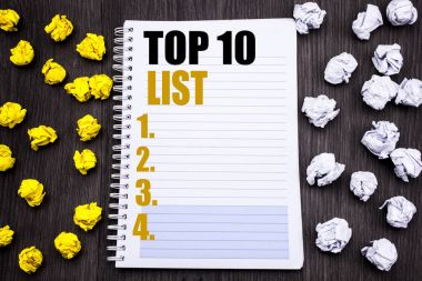 Kavramsal el Top 10 on listesinde gösterilen metin resim yazısı yazma. Sarı ve beyaz iş kavramı için başarı on listesi yazılı not defteri Not defter kitap ahşap zemin üzerine yapışkan katlanmış