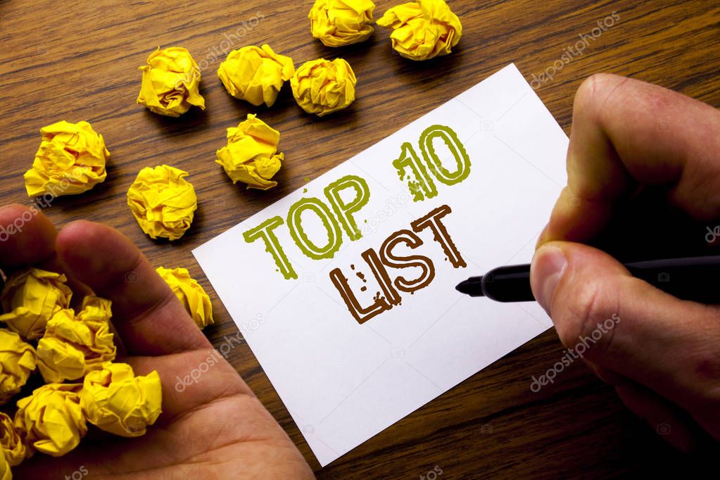 Word, writing Top 10 Ten List. Concept for Success ten list written on notebook note paper on the wooden background with folded paper meaning thinking for idea. Man hand and marker.