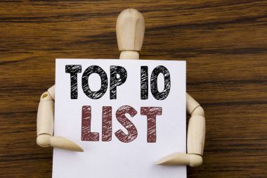 Kavramsal el Top 10 on listesinde gösterilen metin resim yazısı ilham yazma. İş kavramı için başarı on listesi ahşap arka plan üzerinde yapışkan not kağıt üzerinde yazılı. Tarafından heykel holding.