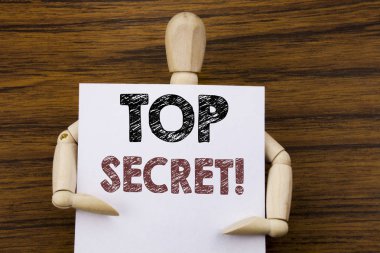 Kavramsal el Top Secret gösterilen metin resim yazısı ilham yazma. İş kavramı için askeri Top Secret ahşap arka plan üzerinde yapışkan not kağıt üzerinde yazılı. Tarafından heykel holding.