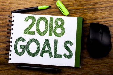 2018 hedefleri gösteren el yazısı duyuru metin. Defter kitap bir not kağıdına ahşap arka plan üzerinde yazılı yeni Yer çözünürlükler için iş kavramı. Yeşil word mektup. Fare için ileri.