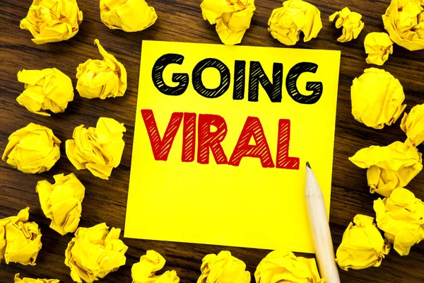 Escrevendo texto mostrando Going Viral. Conceito de negócio para Social Viral Business Escrito em papel de nota pegajosa, fundo de madeira com papel amarelo dobrado que significa pensar — Fotografia de Stock