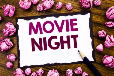 Film gecesi gösterilen metin resim yazısı ilham yazma el. Yapışkan Not kağıt üzerinde yazılı Wathing Filmler, katlanmış pembe kağıt anlam düşünce ile ahşap arka plan için iş kavramı