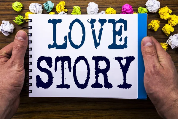 Scrivere testo che mostra Love Story. Business concept per amare qualcuno cuore scritto sul taccuino taccuino libro sullo sfondo in legno con uomo d'affari mano e dito . — Foto Stock