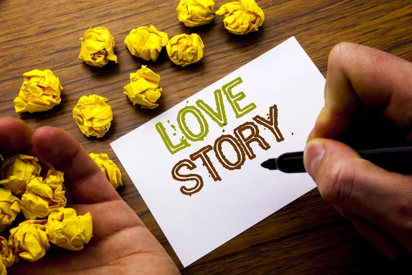 Parola, scrivere Love Story. Concetto per amare qualcuno cuore scritto su carta nota taccuino sullo sfondo di legno con carta piegata che significa pensare per idea. Uomo mano e marcatore . — Foto Stock