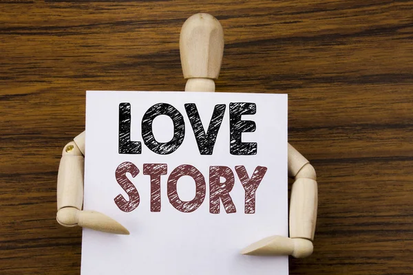Concettuale mano scrittura testo didascalia ispirazione che mostra Love Story. Business concept per Loving Someone Heart scritto su carta appiccicosa sullo sfondo in legno. Tenuta dalla scultura . — Foto Stock