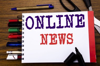 Online haber gösteren el yazısı duyuru metin. İş kavramı Online gazete makalede yazılı üstünde defter, kalem gibi Ofis donanımı ile ahşap arka plan için renkli marker makas  