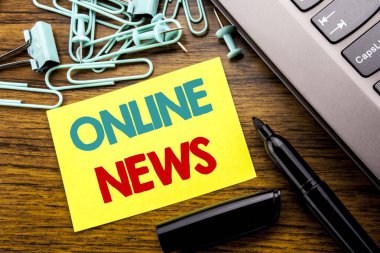 Online haber gösteren el yazısı duyuru metin. Online gazete laptop klavye yanında ahşap arka plan yapışkan not kağıdına marker ile yazılı makale için iş kavramı