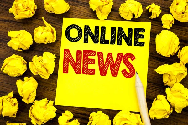 Writing text showing Online News. Business concept for Online Newspaper Article Written on sticky note paper, wooden background with folded yellow paper meaning thinking