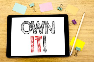O kendi ünlem gösterilen metin yazma. Sahiplik denetimi yazılı tablet laptop, yapışkan not ve kalem ile ahşap arka plan için iş kavramı
