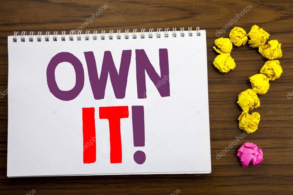 Conceptual hand writing caption inspiration showing Own It Exclamation. Business concept for Ownership Control written on notepad note paper on the wooden background with question mark.