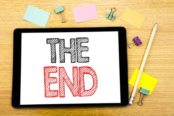 Escrevendo texto mostrando The End. Conceito de negócio para acabamento final Fechar Escrito em tablet laptop, fundo de madeira com nota pegajosa e caneta — Fotografia de Stock