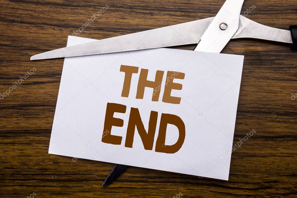 Hand writing text caption inspiration showing The End. Business concept for End Finish Close Written on note, wooden back with colourful scissors meaning destroy stop of something.