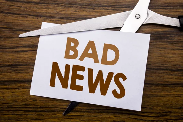 Hand writing text caption inspiration showing Bad News. Business concept for Failure Media Newspaper Written on note, wooden back with colourful scissors meaning destroy stop of something. Royalty Free Stock Images